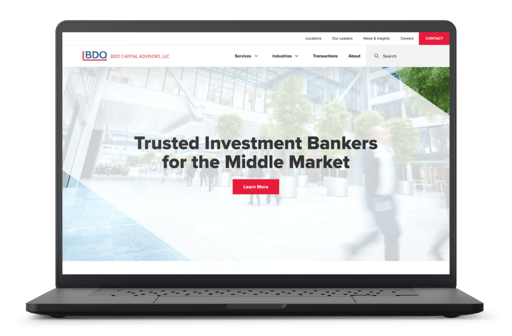 A laptop displaying the BDO Capital Advisors website homepage, featuring a banner with the headline "Trusted Investment Bankers for the Middle Market" and a red "Learn More" button. The navigation menu at the top includes links for Services, Industries, Transactions, About, and more. The background image of the banner shows a modern office building with glass windows and trees, creating a professional atmosphere.