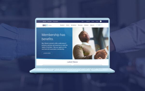 Mockup of the Big I Illinois website displayed on a laptop screen, showcasing the homepage with the headline 'Membership has benefits.' The background features a handshake image overlaid with a blue tint, emphasizing collaboration and professional connections.