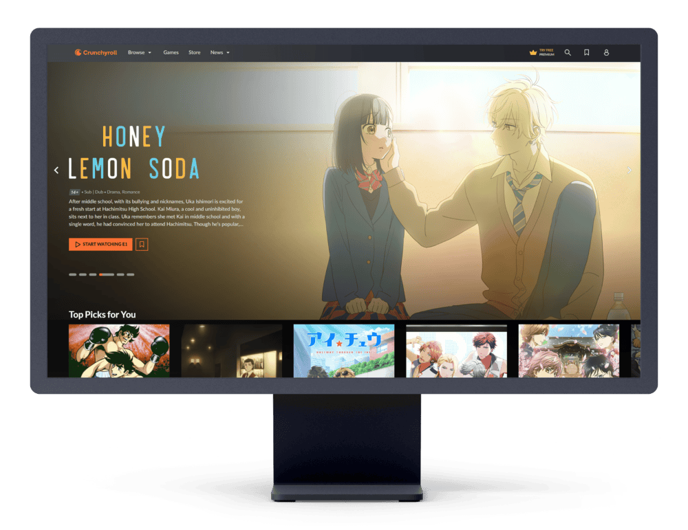 Screenshot of the Crunchyroll website displayed on an gray monitor. The featured content highlights the anime 'Honey Lemon Soda,' showcasing a warm and heartfelt scene between two characters in a sunlit classroom. The page includes options to 'Start Watching,' along with personalized recommendations in the 'Top Picks for You' section below, offering a glimpse into Crunchyroll's engaging and user-friendly interface.