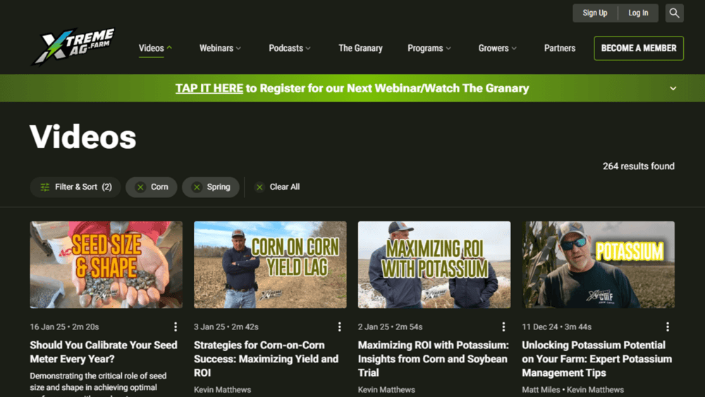 A webpage from XtremeAg displaying a filtered video search results page. The interface has a dark theme with green highlights and features a 'Filter & Sort' section with selected filters for 'Corn' and 'Spring.' The page shows 264 results, with video thumbnails and titles on topics such as seed calibration, corn yield lag, and maximizing ROI with potassium. A banner at the top invites users to register for a webinar or watch The Granary.